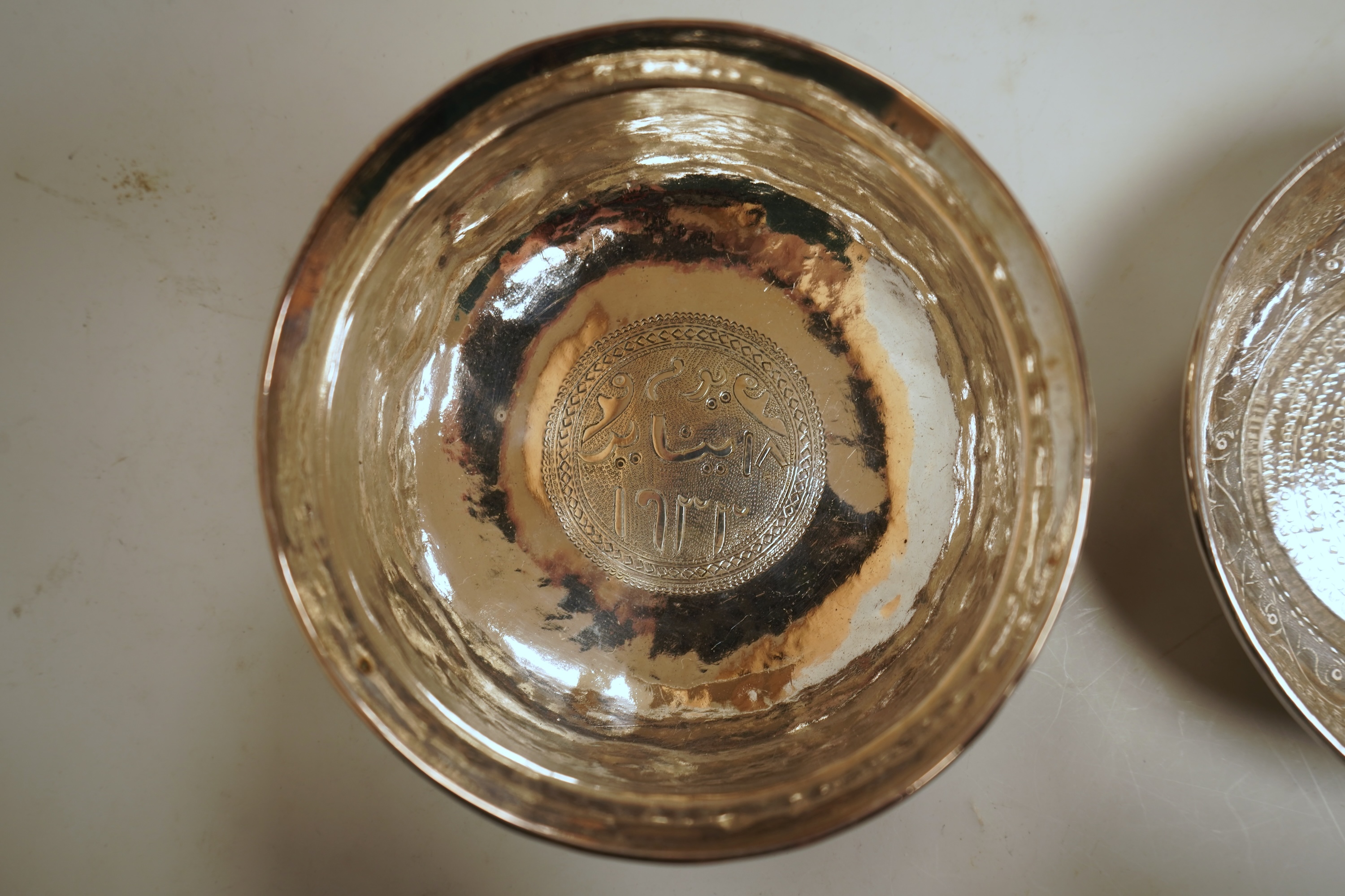 Two early to mid 20th century Persian engraved white metal bowls, both diameters approximately 11.5cm.